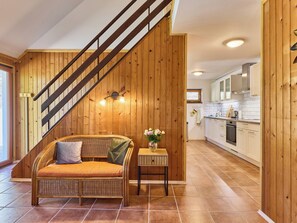A modern kitchen with white cabinets and a wooden staircase.
