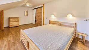 A bedroom with a wooden bed, a dresser, and a bench. - Kyjov u Krásné Lípy by Interhome (Krasna Lipa)