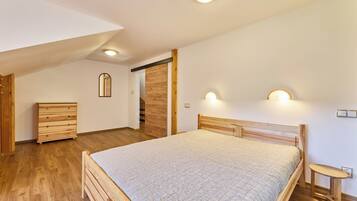 Une chambre à coucher avec un lit en bois, une commode et un banc.