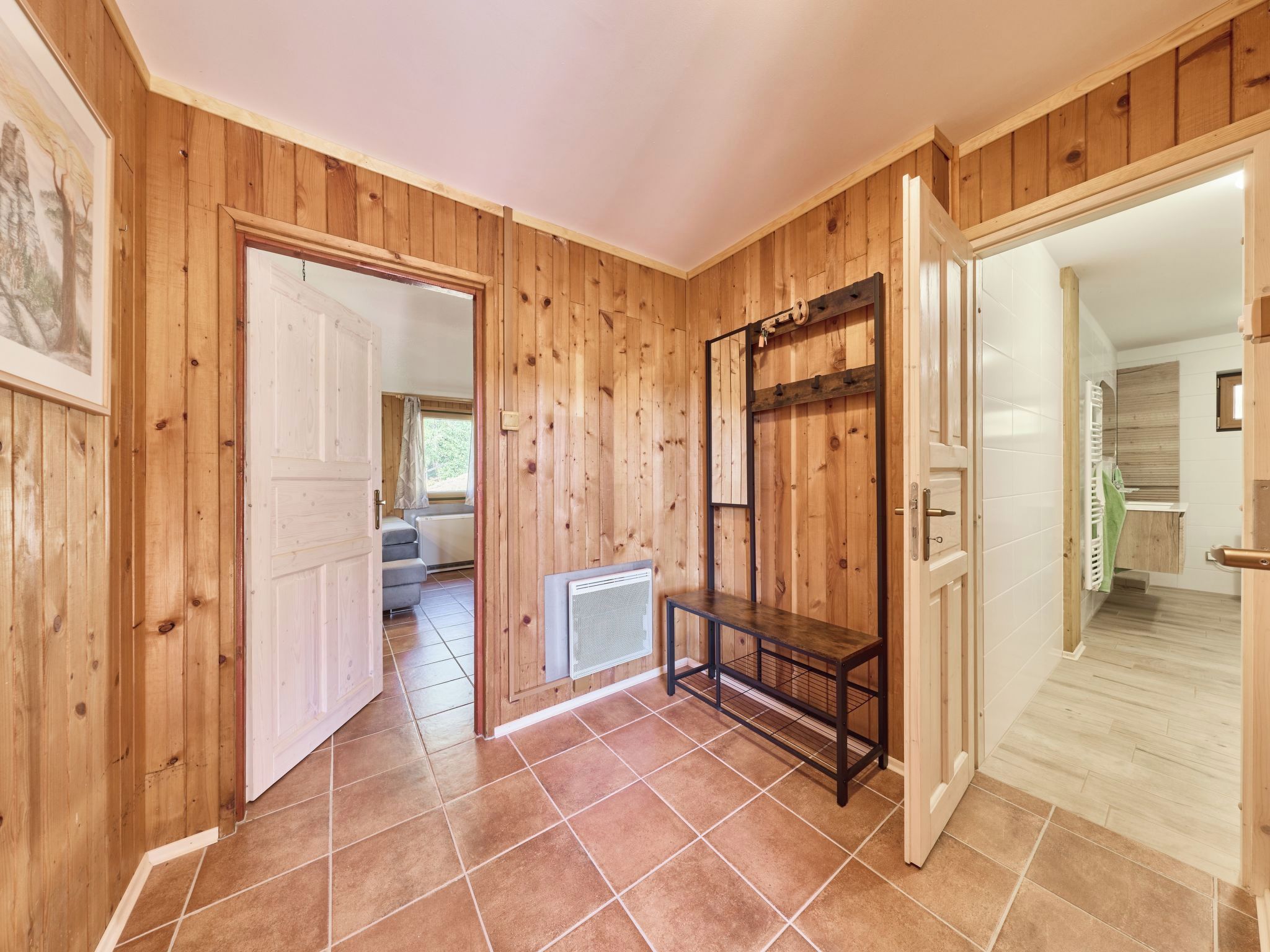 Un intérieur en bois avec un plancher carrelé, un radiateur et un banc.