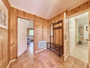 A wooden interior with a tiled floor, a radiator, and a bench.