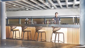 A bar area with a pool, bar stools, and a bartender. - Kingsford Hotel Manila Bay (Parañaque)