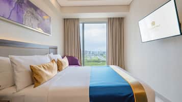Une chambre d’hôtel avec un grand lit, une vue sur la ville et un tableau encadré au mur.