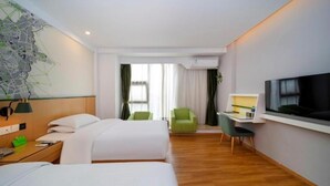Habitación de hotel con dos camas, un escritorio con televisor, un mapa en la pared y una ventana con cortinas.