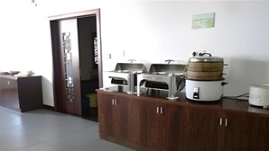 A kitchen with a wooden countertop, a rice cooker, a pressure cooker, and a stove.
