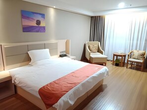 A hotel room with a large bed, a chair, a small table, and a painting on the wall. - Shell Putian Hanjiang District Hanhua West Road Hotel (Putian)