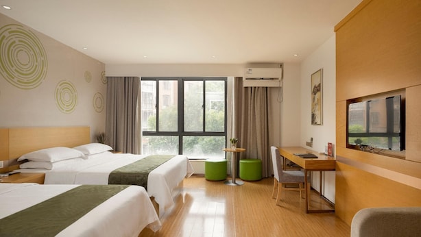 A hotel room with two beds, a desk, a chair, a TV, and a window with curtains. - Greentree Inn Wuxi Yixing Xushe Town Government Ex (Wuxi)