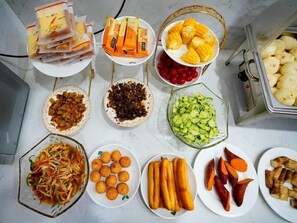 A variety of food items including corn, sweet potatoes, and various fruits and vegetables arranged on a table. - Greentree Inn Wuxi Yixing Xushe Town Government Ex (Wuxi)