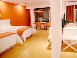 Habitación de hotel con dos camas, un escritorio y una silla.