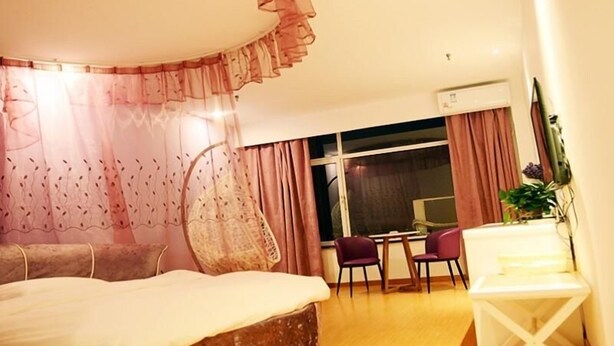 A bedroom with a large bed, a desk, two chairs, and a small table. - Shell Xizhou Xifu District West Heping Street Hotel (Xinzhou)