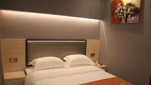 A hotel room with a bed, nightstand, and a painting on the wall. - Shell Shanghai Chedun Yingshi City Yingshi Road Hotel (Shanghai)