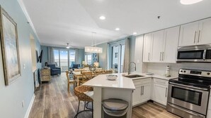 Una cocina moderna con armarios blancos, electrodomésticos de acero inoxidable y una isla central.