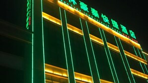 Un hotel con un letrero grande de color verde y amarillo que indica que es el Green Tree Inn Express.