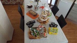 Una mesa servida con diversos alimentos y condimentos, incluyendo bocadillos envasados, pan y una botella de agua.