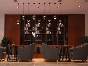 A lobby with a central seating area, a bookshelf, and pendant lighting. - Greentree Eastern Liaocheng Linqing City Yandian Hotel (Liaocheng)