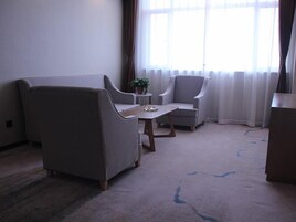 Una sala de estar con sofá, sillón y una mesita.