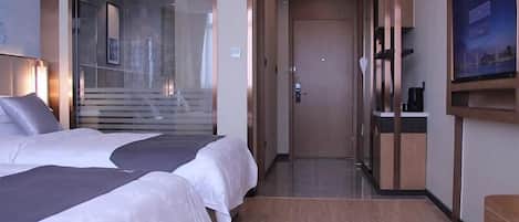 A hotel room with two beds, a TV, and a view of a staircase.