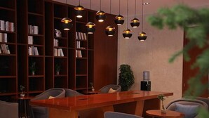 A modern library with a wooden desk, bookshelves, and comfortable seating. - Greentree Eastern Liaocheng Linqing City Yandian Hotel (Liaocheng)