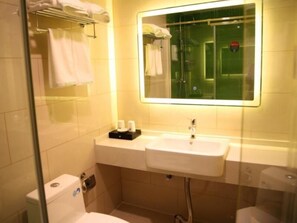 A modern bathroom with a dual sink, a glass shower enclosure, and a towel rack with towels.
