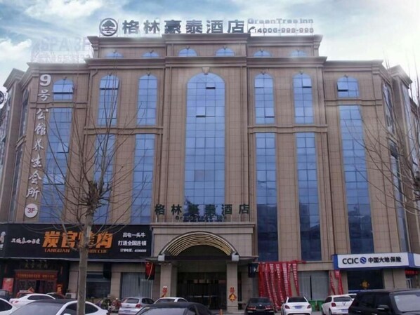 A hotel with a large arched entrance and multiple windows.
