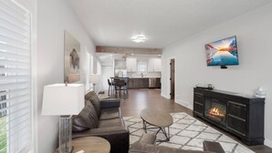 A modern living room with a fireplace, a dining area, and a kitchen in the background. - Newly Re-Finished 2 bed, 1 bath close to downtown (Sheridan)