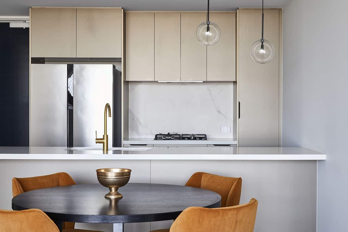 A modern kitchen with a central island, stainless steel appliances, and pendant lighting.