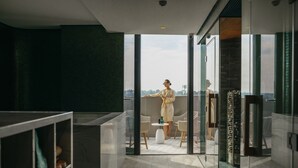 A modern interior with a glass door leading to an outdoor seating area.