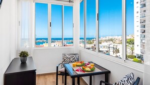 A balcony with a table set for two, overlooking a coastal cityscape. - Rosamar 313 Luxury sea view wifi (Arona)