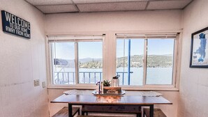 Una habitación con una mesa, dos ventanas, un letrero de bienvenida y un mapa del lago Flathead, Montana.