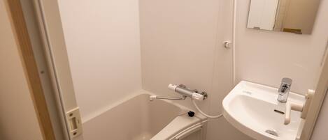 Une salle de bain avec une baignoire blanche, un lavabo blanc et un miroir au-dessus du lavabo.
