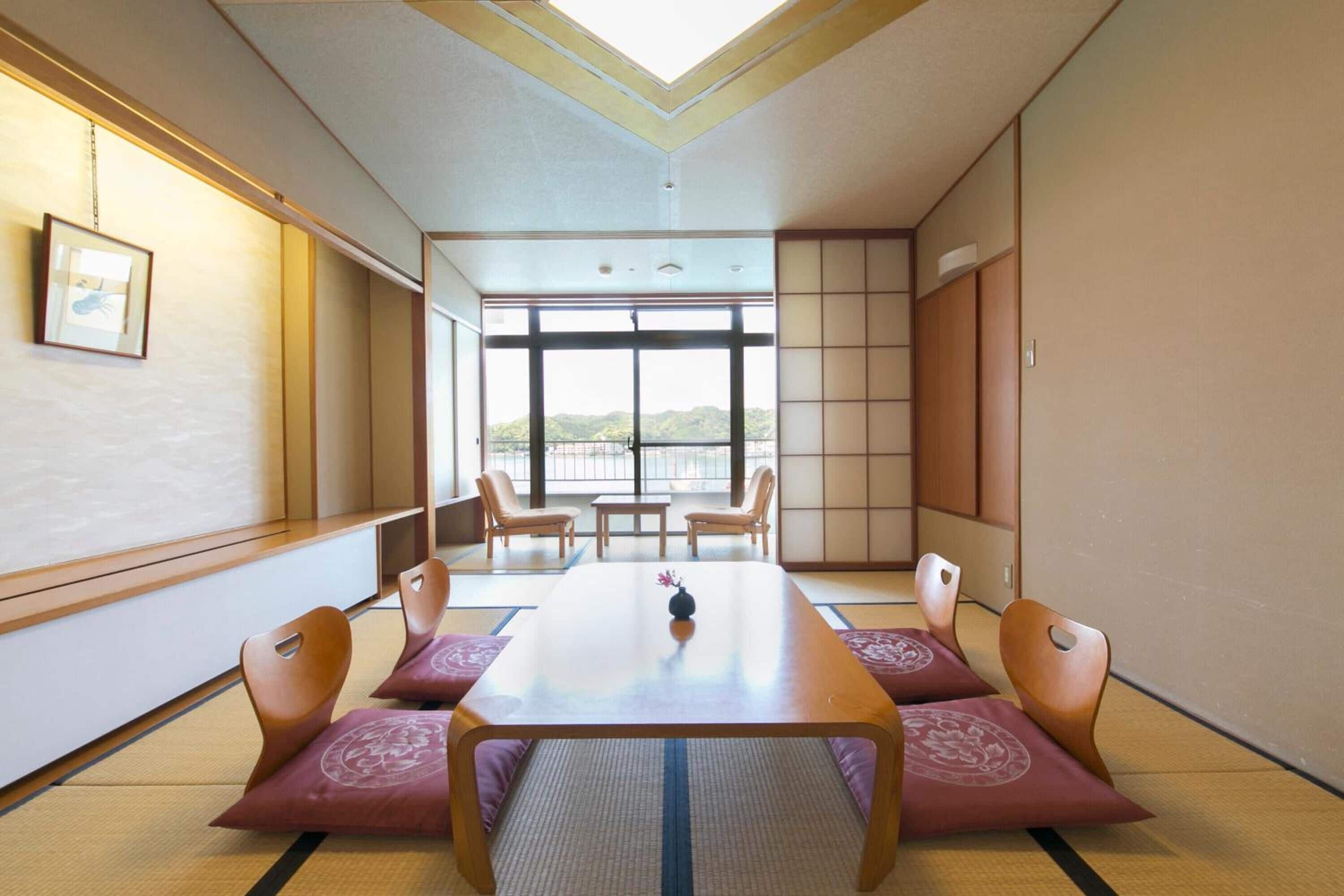A traditional Japanese room with tatami flooring, a low table, and sliding doors.