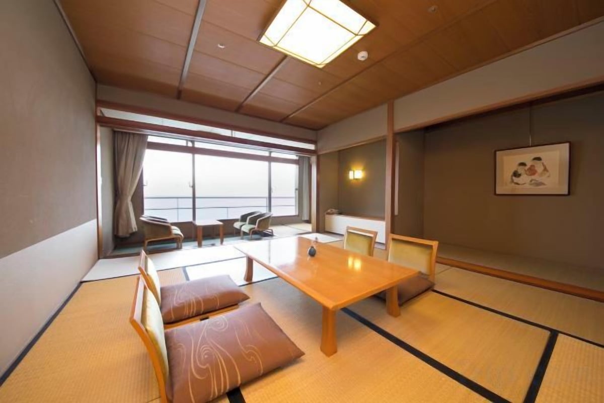 Une pièce de style japonais traditionnel, avec un sol recouvert de tatamis, une table basse et un canapé.