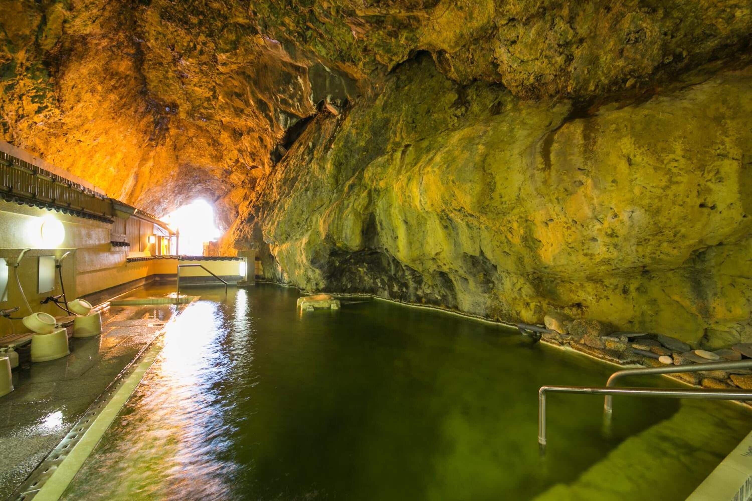 A cave with a swimming pool, benches, and a viewing platform.
