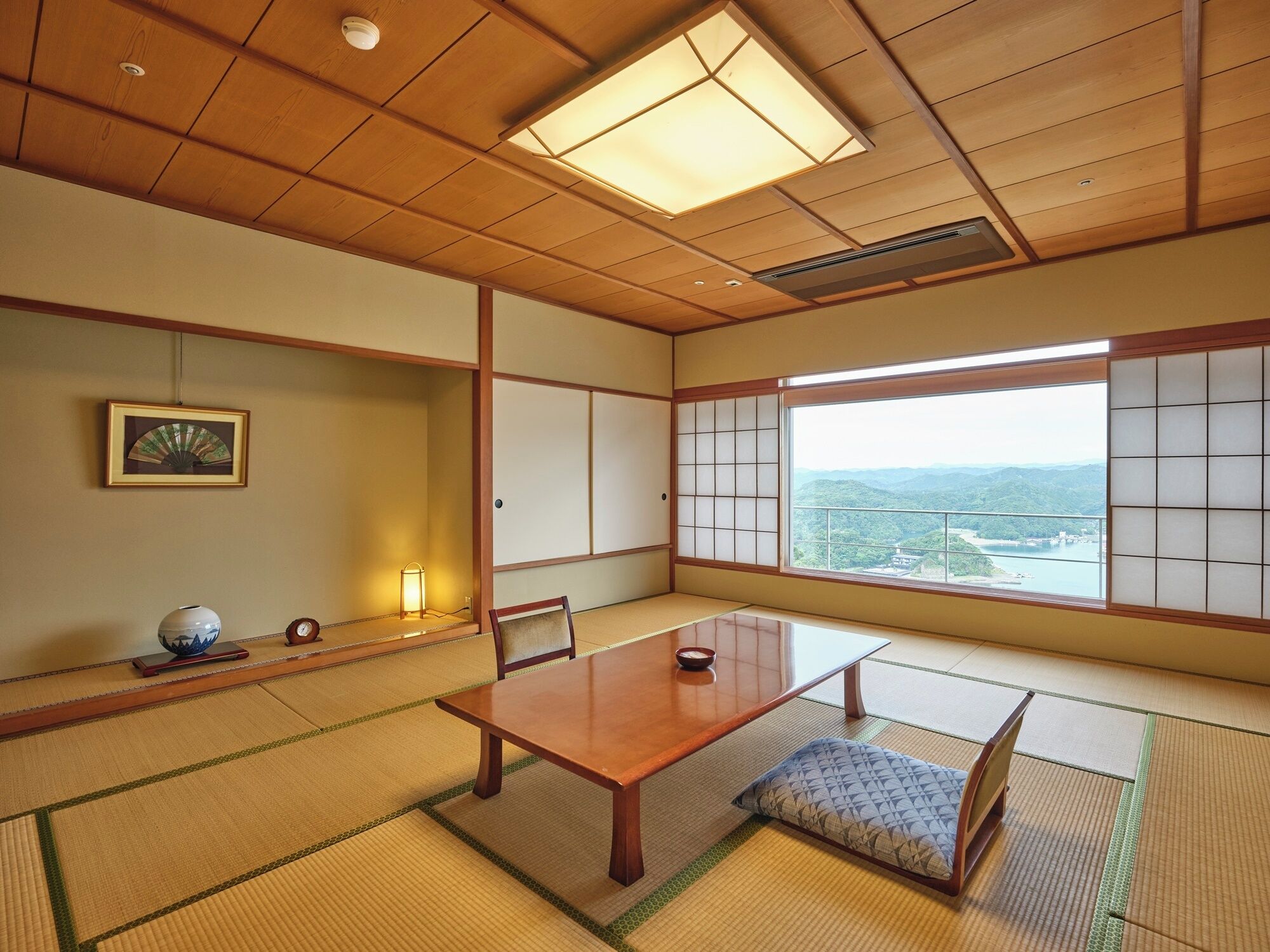A traditional Japanese room with tatami flooring, a low wooden table, and shoji screens.