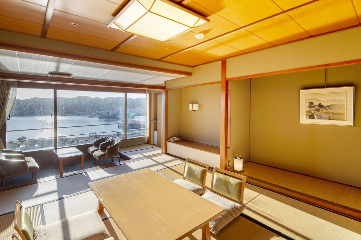 Une pièce de style japonais traditionnel, avec un sol recouvert de tatamis, une table basse et des sièges.