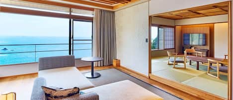 Quarto de hotel moderno com varanda, área de estar e decoração tradicional em estilo japonês.