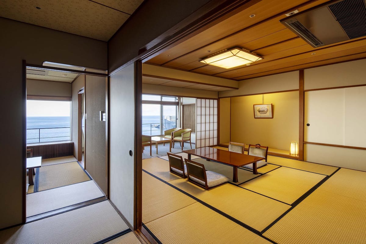 Une pièce de style japonais traditionnel, avec un sol recouvert de tatamis, une table basse et des chaises.