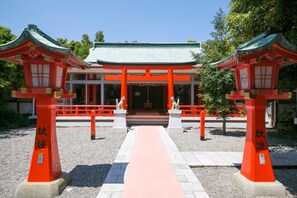 A traditional Japanese torii gate leading to a building with a tiled roof. - Hotel Urashima (Nachikatsuura)