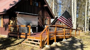 Een rustieke chalet met een veranda en een vlag.