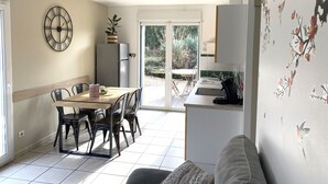 A modern kitchen with a dining area, a refrigerator, and a sink.