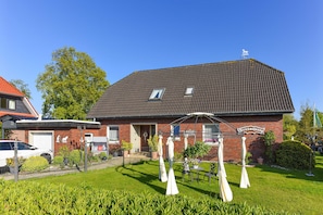 A two-story brick building with a red roof, a small porch, and a sign that reads "Verwaltungsgebäude".