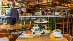 A restaurant with a bar area, wooden tables, and chairs. - Debrah Brown (Tel Aviv)