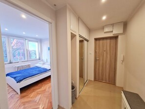 A bedroom with a bed, a window, and a radiator.