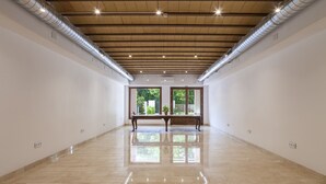 A spacious, well-lit room with a polished floor, large windows, and a bench. - Ad Hoc Vitae Retreats & Health - Adults Only (Beniarbeig)