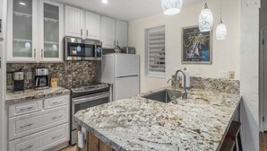 A kitchen with white cabinets, a granite countertop, stainless steel appliances, and pendant lighting. - Crestview 30: Free EV Charger, Walk to The Village (Mammoth Lakes)