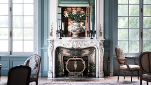 A grand room with a fireplace, ornate chairs, and a large vase with flowers. - Château la Gauchetiere Avec Piscine (Chailloué)