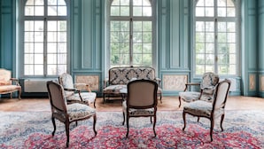 A room with three upholstered chairs, a patterned rug, and large windows with decorative frames. - Château la Gauchetiere Avec Piscine (Chailloué)