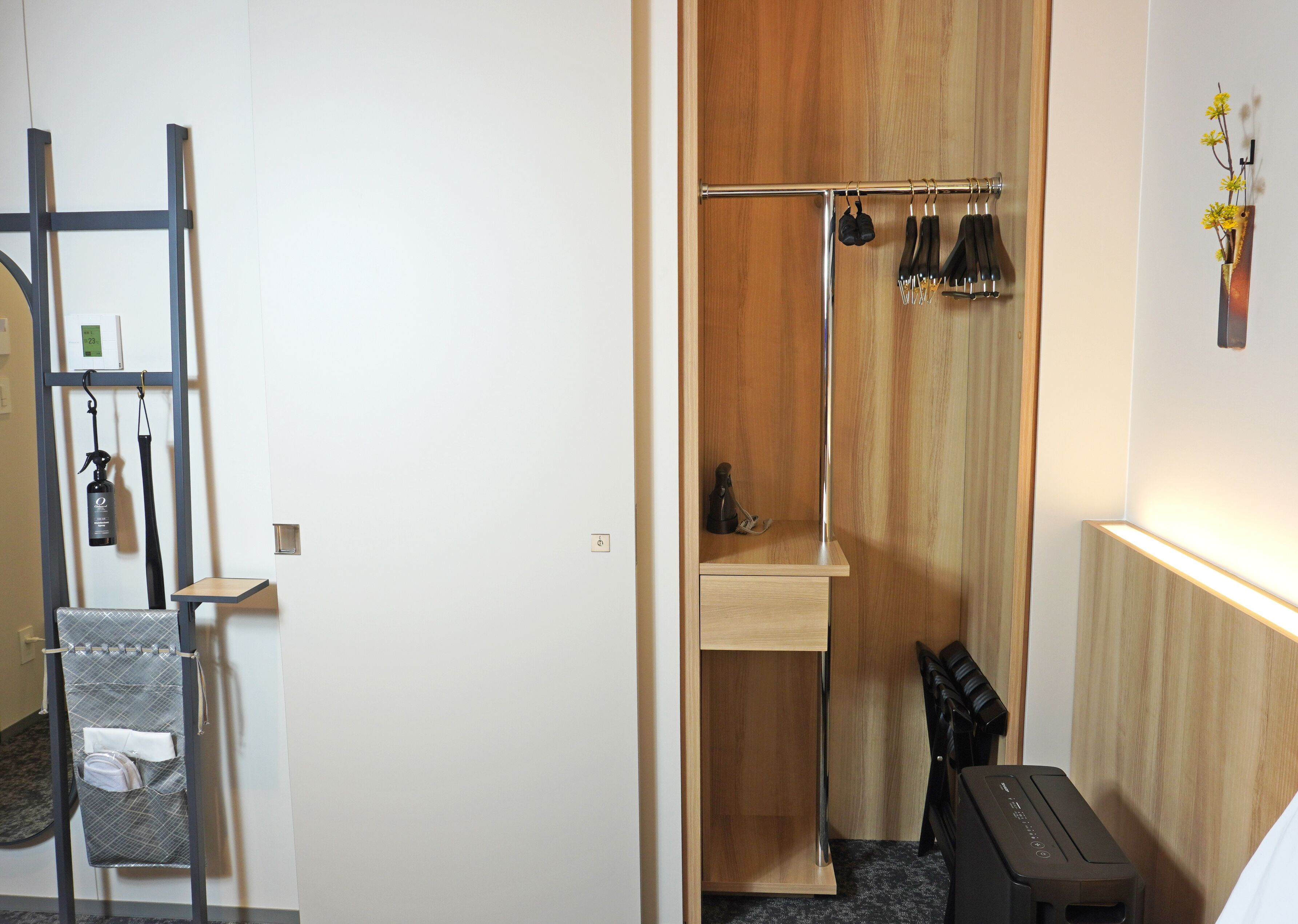 A compact bathroom with a wooden vanity, a towel rack, and a small shelf.