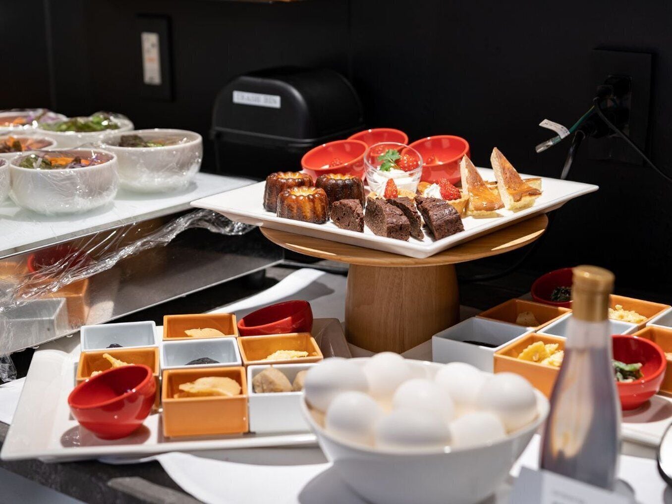 A buffet with various dishes, including desserts and a bowl of white spherical items, likely ice cream.