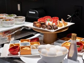 A buffet with various dishes, including desserts and a bowl of white spherical items, likely ice cream.